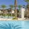 a pool with palm trees and a building in the background